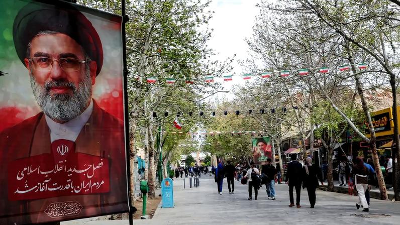 Pessoas caminham em rua com pôsteres do novo líder supremo do Irã, Mojtaba Khamenei, em Isfahan, no Irã. Foto: REUTERS/Alaa Al Marjani