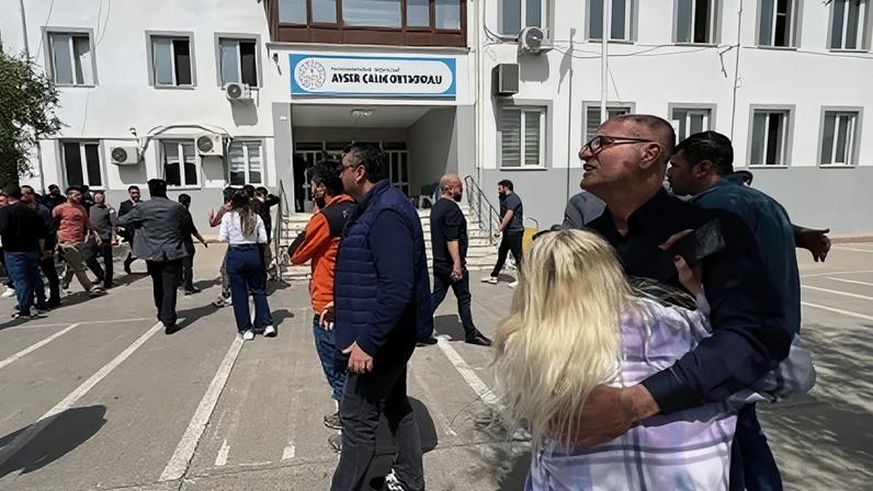 Pessoas esperam em frente ao prédio da escola após ataque no sudeste da Turquia nesta quarta-feira (15)