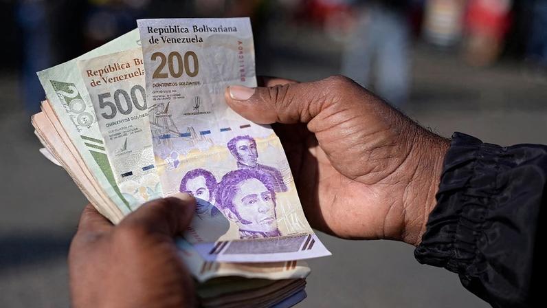 Um homem mostra as novas cédulas de 200 e 500 bolívares em Caracas, Venezuela, em 3 de setembro de 2024. REUTERS/Gaby Oraa