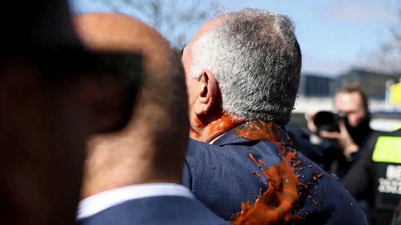 Reza Pahlavi, filho exilado do último xá do Irã e figura da oposição iraniana, com o rosto manchado de uma substância vermelha, sai após uma coletiva de imprensa na sede da Conferência Federal de Imprensa (Bundespressekonferenz) em Berlim, Alemanha, em 23 de abril de 2026. REUTERS/Liesa Johannssen