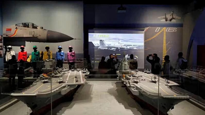 Visitantes observam réplicas dos porta- aviões Liaoning e Shandong, em exibição no Museu Naval do Exército de Libertação Popular (ELP) no 75º aniversário de fundação da Marinha do ELP, em Qingdao, província de Shandong, China , em 23 de abril de 2024