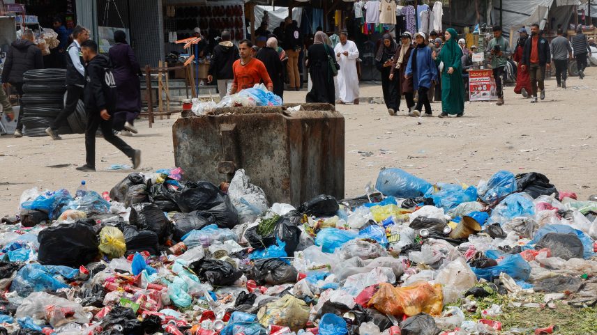 Palestinos passam por pilhas de lixo e resíduos perto de tendas de deslocados em meio à proliferação de roedores em Khan Younis, no sul da Faixa de Gaza, em 27 de abril de 2026. — Foto: REUTERS/Haseeb Alwazeer