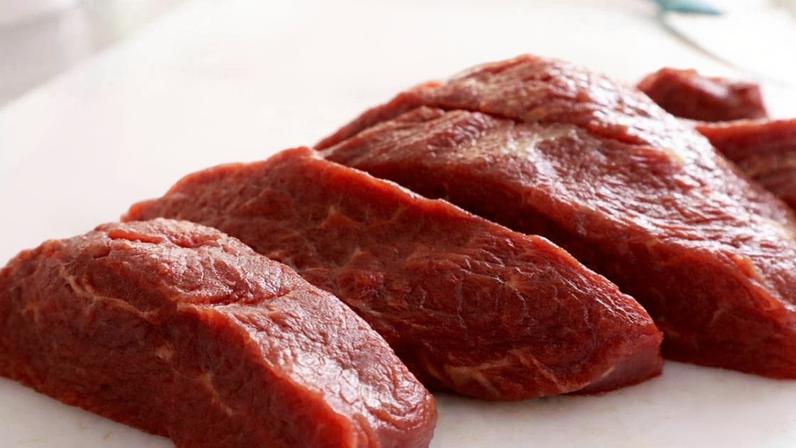 Peças de carne bovina crua sobre uma mesa branca