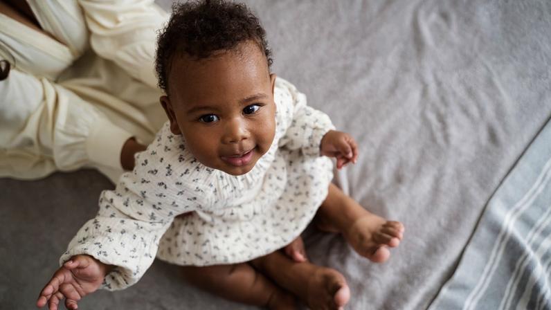 Bebê sentado com a mãe — Foto: Freepik
