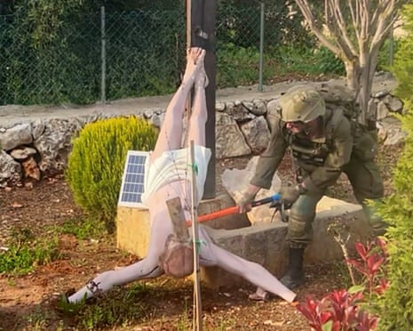 A soldier holding or swinging a sledgehammer over an upside-down statue of Jesus