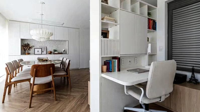 A estante da sala de estar funciona como divisória vazada e multifuncional para o home office, delimitando os ambientes sem isolá-los e mantendo a integração — Foto: Renan Soares/Divulgação | Projeto das arquitetas Thais Couto e Letícia Gomes do escritório MUVU Arquitetura e Interiores