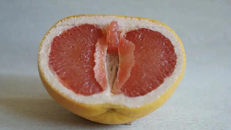 Símbolo da vulva, clitóris e lábios vaginais. A toranja tem a forma de uma vulva (vagina), com o clitóris e os lábios. Conceito de genitália feminina.