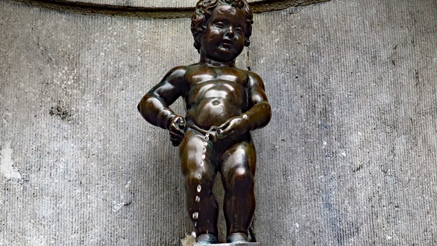 Fotografia de uma pequena fonte de bronze que representa um menino urinando.