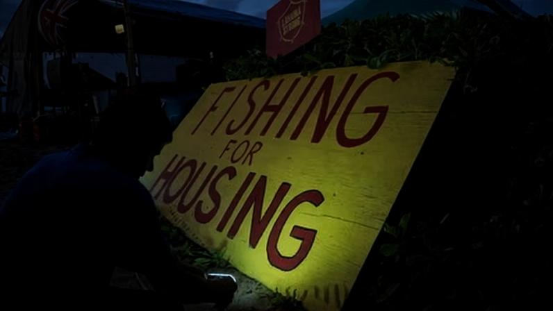 A volunteer with Lahaina Strong sets up lights on a protest sign at Kaanapali beach in Lahaina, Hawaii, on 16 December 2023.