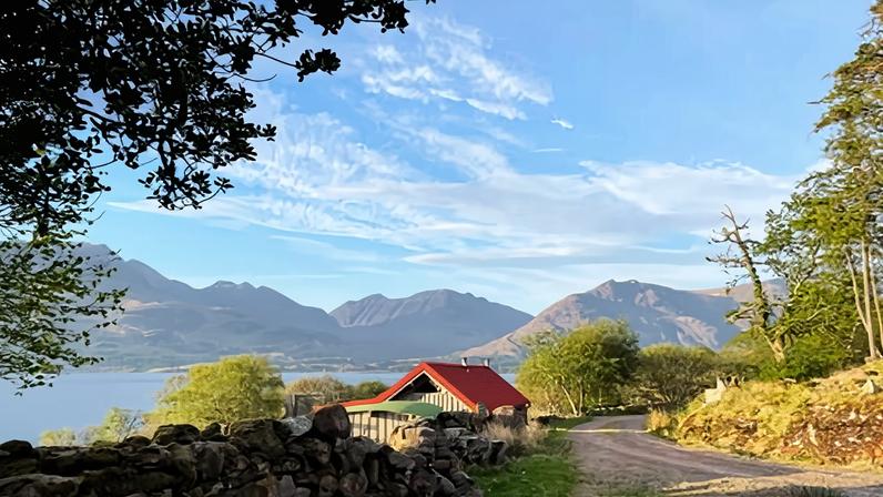 The cheery red roof of Ben Damph bothy on Loch Torridon