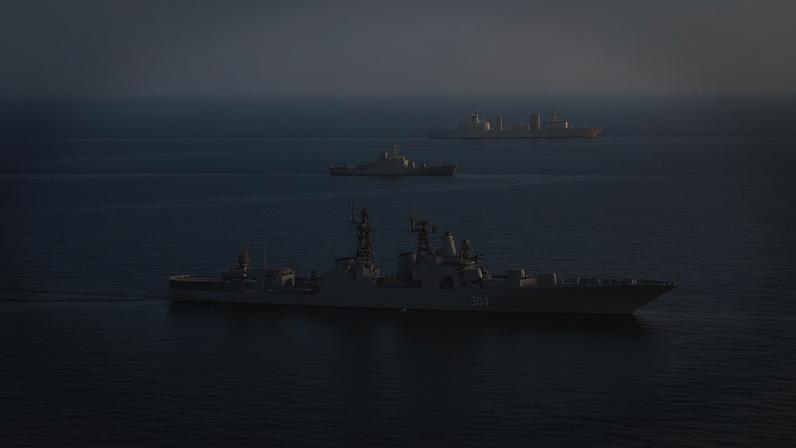 Navios militares navegando pelo mar em formação, sob céu encoberto