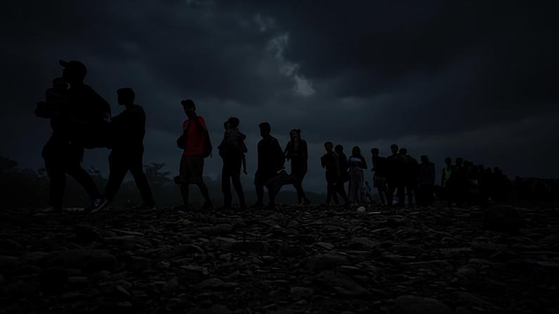 Migrants walk by the jungle near Bajo Chiquito village, the first border control of the Darién province in Panama, on 22 September 2023.