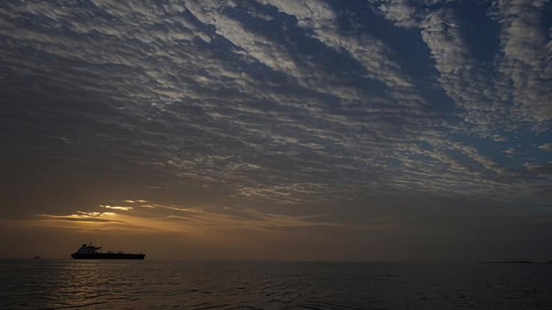 The sun rises behind a tanker anchored in the strait of Hormuz off the coast of Qeshm Island.