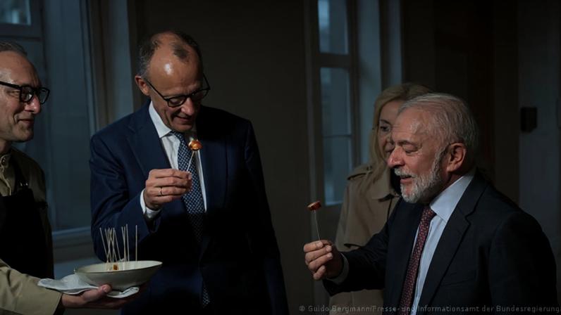 Lula provando salsichas em ambiente "gourmet" com Merz. Aparentemente não era o que o brasileiro queria