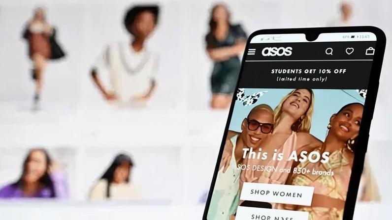 AFP via Getty Images An illustration with a laptop and mobile phone shows the website of online fashion retailer ASOS on August 12, 2021.