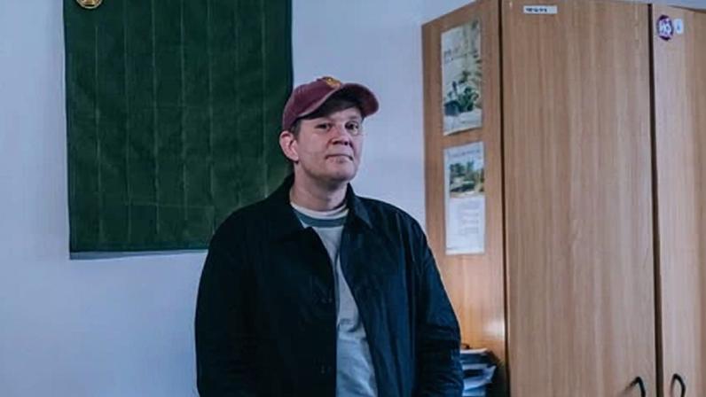 Oleksandr at the rehab clinic, wearing a baseball cap and dark blue jacket