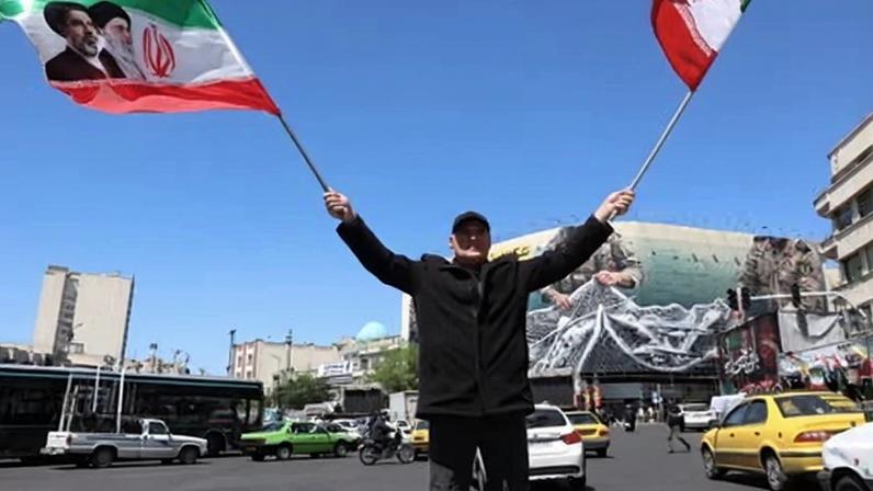 A man waves Iranian national flags in Enghelab Square, Tehran. Some commentators feel the country has shown remarkable political resilience.