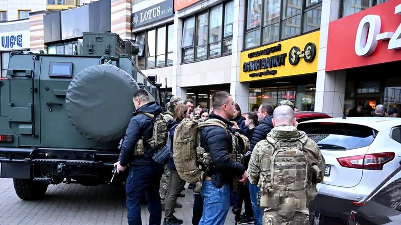 Armed officers gather outside a supermarket where a gunman took hostages in the Holosiivskyi district of Kyiv, Ukraine, on Saturday.