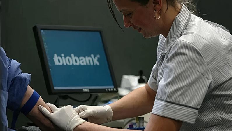 Nurse taking blood from person as biobank logo appears on screen in background.