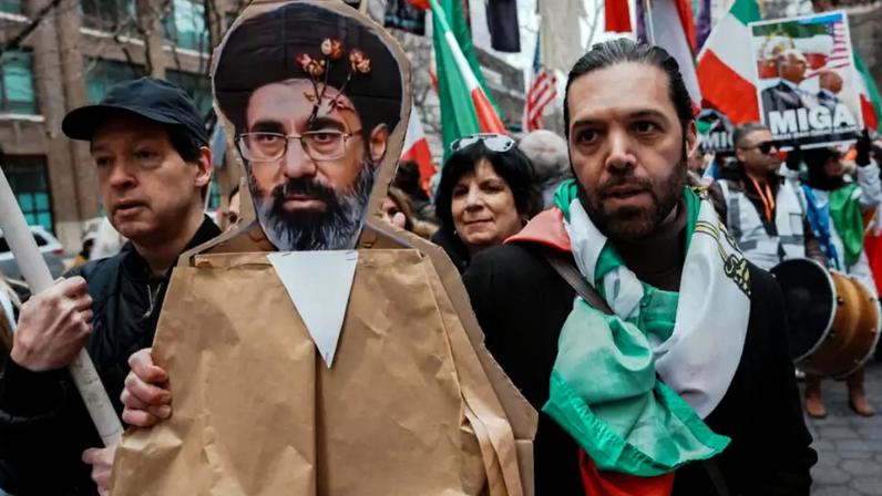 Um manifestante segura uma imagem do novo líder supremo do Irã, Mojtaba Khamenei, durante um protesto contra o governo iraniano, em Manhattan, Nova York, Estados Unidos, 15 de março de 2026.