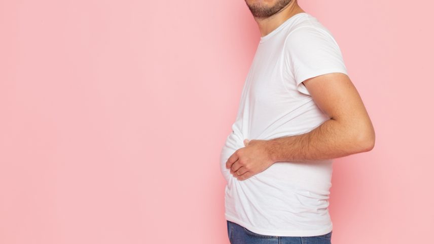 Homem de perfil apertando a barriga - Metrópoles