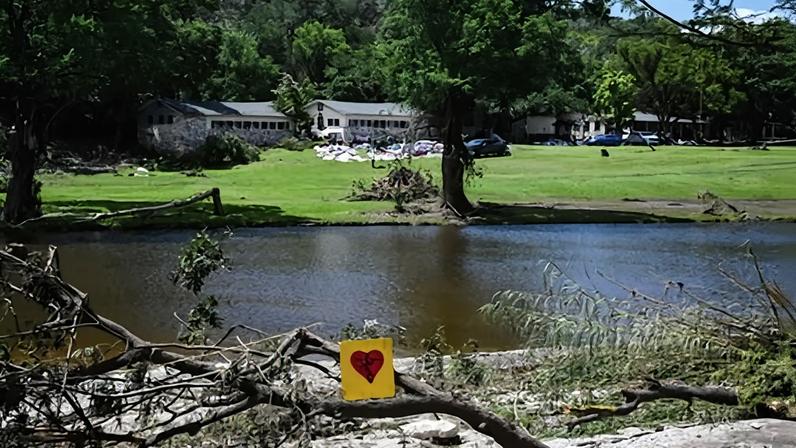 A painted broken heart is seen near Camp Mystic along the Guadalupe River in Hunt, Texas, on 8 July 2025, after severe flash flooding.