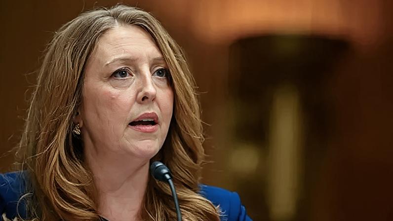 Means seen testifying to Congress, wearing a blue suit