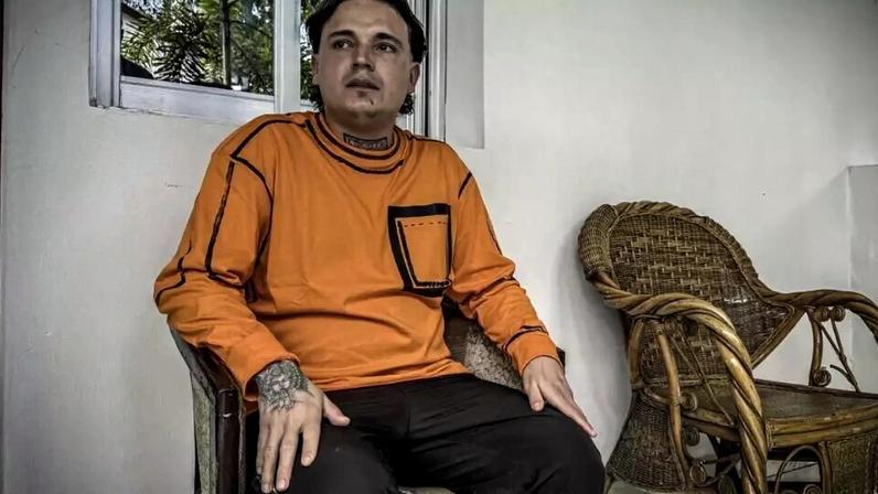 Hugo Palencia Ropero, 25 anos, cidadão colombiano expulso dos Estados Unidos, sentado do lado de fora de seu quarto em um hotel em Kinshasa em 22 de abril de 2026.