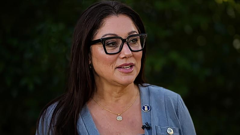 Getty Images Lori Chavez-Deremer in grey sweater, gold necklace, and black glasses