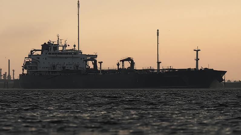 Ian Forsyth/Getty Images An oil tanker at sea silhouetted against a sky at sunset.