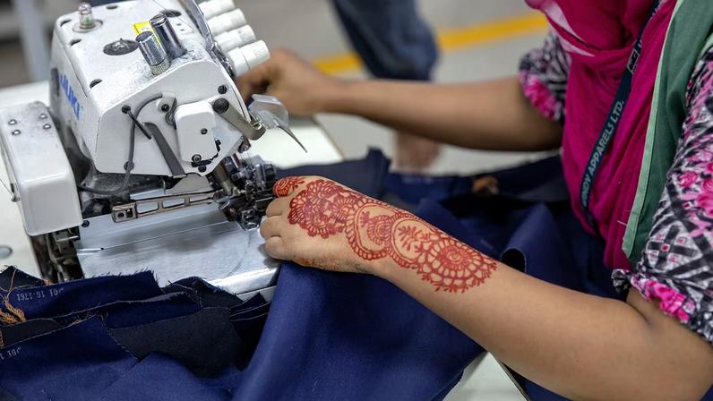 A garment worker sewing in a factory in Bangladesh.