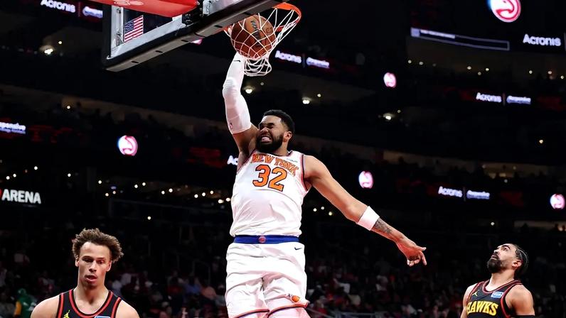 Karl-Anthony Towns, do New York Knicks, enterra sobre Dyson Daniels e Gabe Vincent, do Atlanta Hawks, na State Farm Arena. (Foto: Kevin C. Cox/Getty Images/AFP)