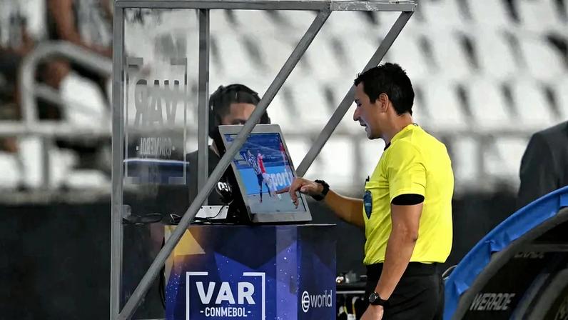 O árbitro peruano Kevin Ortega consulta o VAR durante a partida da fase de grupos da Copa Sul-Americana (Foto: Mauro PIMENTEL / AFP)