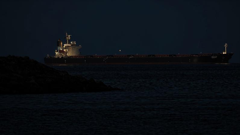 Um navio cargueiro é fotografado ao largo da cidade costeira de Fujairah, no Estreito de Ormuz, no emirado do norte, em 25 de fevereiro de 2026