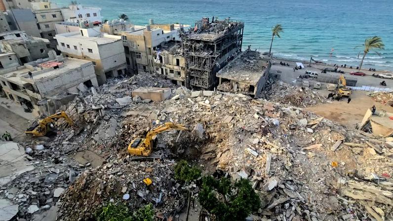 Escavadeira remove os escombros do local de um ataque aéreo israelense que atingiu um bairro na cidade costeira de Tiro, no sul do Líbano, no dia 17 de abril de 2026, quando o cessar-fogo com Israel entrou em vigor