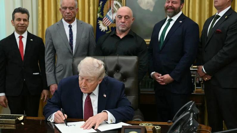 O comissário da FDA, Marty Makary, o secretário de Saúde, Robert F. Kennedy Jr., o apresentador de TV americano Joe Rogan, W. Bryan Hubbard, CEO da Americans for Ibogaine, e o ex-SEAL da Marinha, Marcus Luttrell, observam Trump assinar decreto na Casa Branca, em 18 de abril de 2026