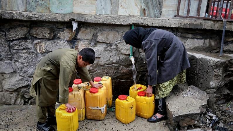 A boy and a girl collect water from a hose connected to a well at a mosque in Deh Mazang, Kabul, Afghanistan, Thursday, April 2, 2026. Image by Siddiqullah Alizai via Associated Press