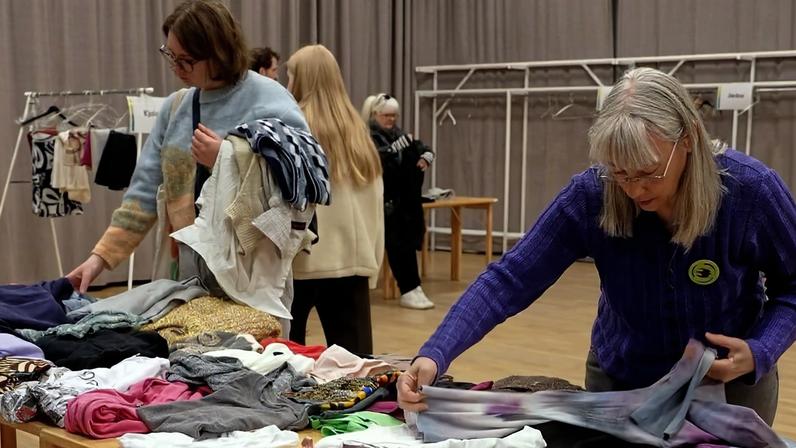 Meg Goldmann, right, a volunteer with the Swedish Society for Nature Conservation, folds secondhand clothes at a clothing swap event in Stockholm, Sweden, Saturday, April 19. 2026. (AP Photo/Chisato Tanaka)