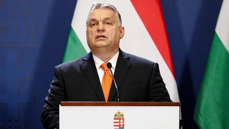 Viktor Orbán, primeiro ministro da Hungria discursa em púlpito com a bandeira do país atrás. Seu discurso com tendências nazistas levou ministra do governo a renunciar - Metrópoles