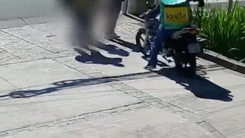 Suspeito em motocicleta aborda casal, anuncia assalto e atira em homem que tentou intervir; vítima foi atingida na cabeça e caiu na calçada, enquanto o criminoso fugiu