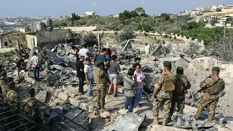 Soldados libaneses e moradores locais observam o local de um ataque aéreo israelense na vila de Toura, no sul do Líbano, em 6 de novembro.