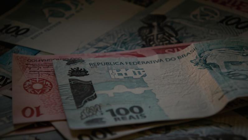 Notas de real brasileiro, com destaque para a cédula de 100 reais