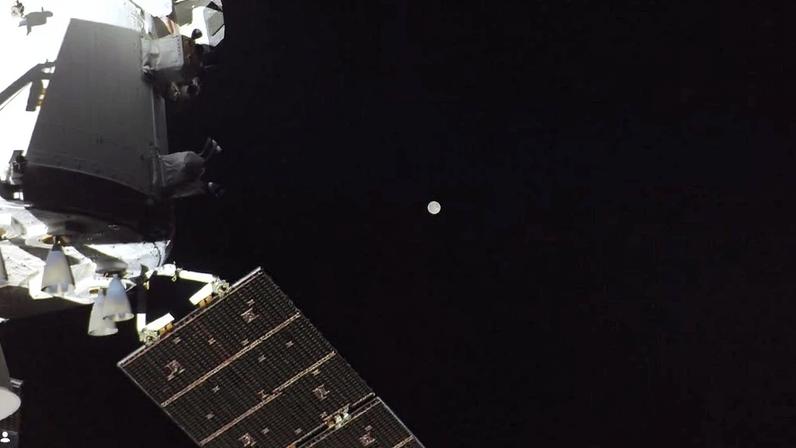 Imagem da cápsula Orion no espaço profundo com a Lua ao fundo