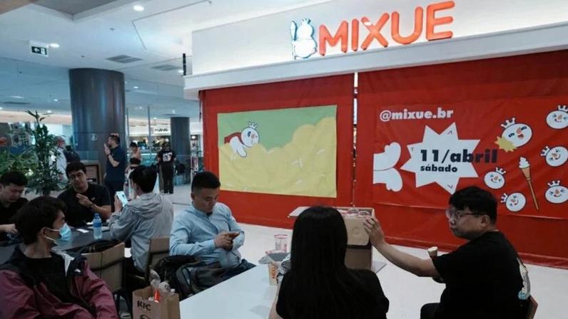 Funcionários da chinesa Mixue descansam do lado de fora da primeira loja brasileira da empresa em São Paulo