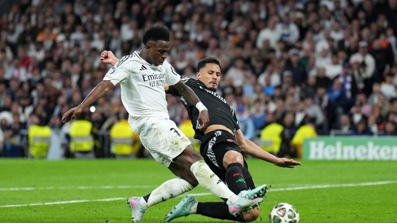 Vinicius Junior e William Saliba disputam bola