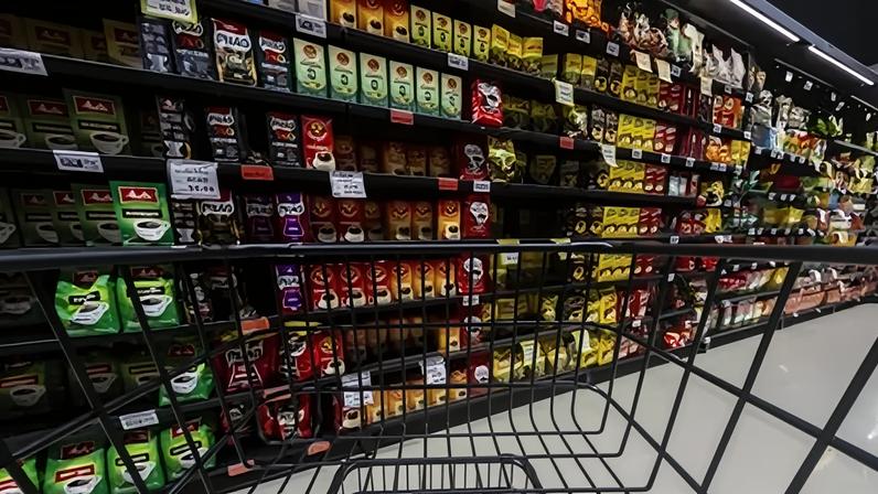 Carrinho vazio parado na frente das prateleiras com diferentes marcas de café e preços diversos no interior de um supermercado na cidade de Marília, no interior de São Paulo