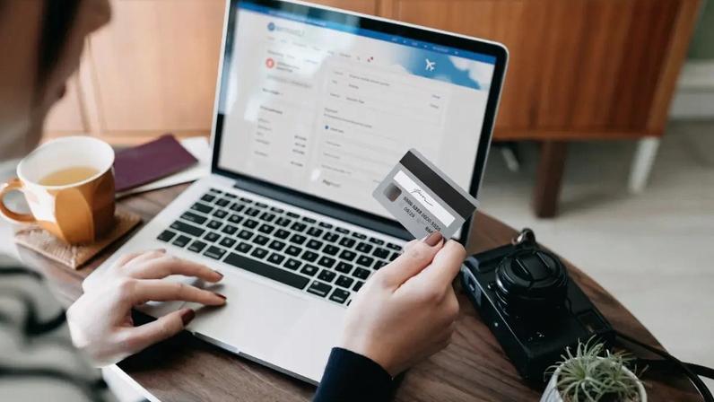 Mulher usa cartão de crédito para fazer compra online