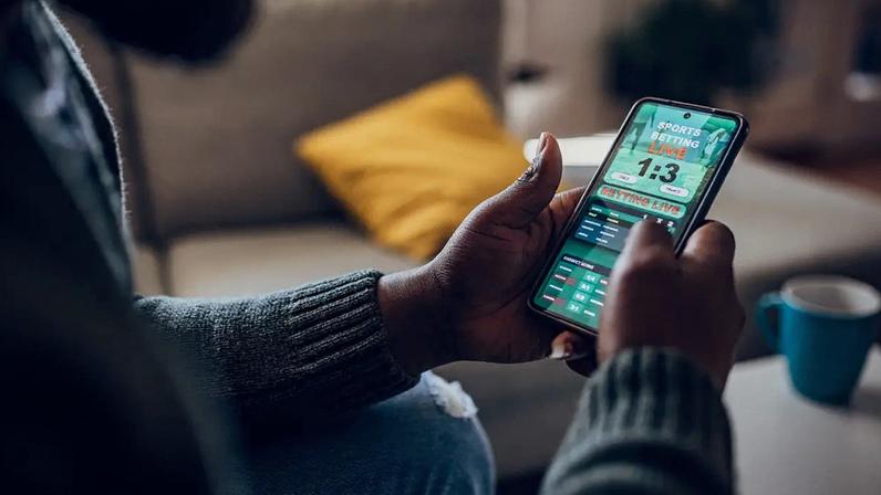 Celular com jogo de aposta online (E+/Getty Images)