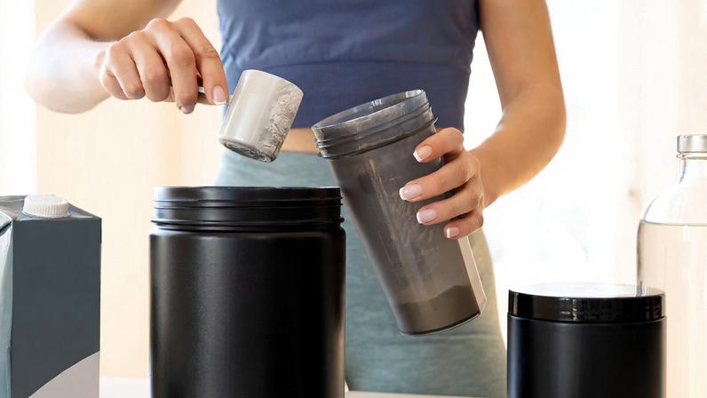 Mãos de mulher preparando bebida com Whey Protein - Metrópoles