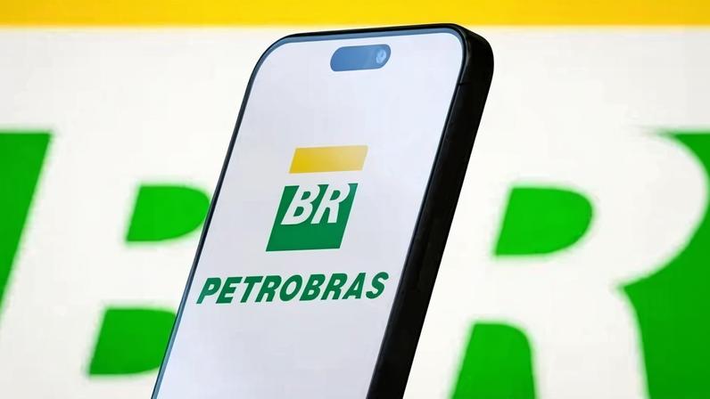 CHONGQING, CHINA - MAY 11: In this photo illustration, the logo of Petróleo Brasileiro S.A. (Petrobras) is displayed on a smartphone screen, with the company's green and yellow branding visible in the background, on May 11, 2025, in Chongqing, China. Petrobras is a Brazilian multinational energy corporation primarily engaged in oil and gas exploration, production, refining, and transportation, and is one of the largest companies in Latin America. (Photo illustration by Cheng Xin/Getty Images)